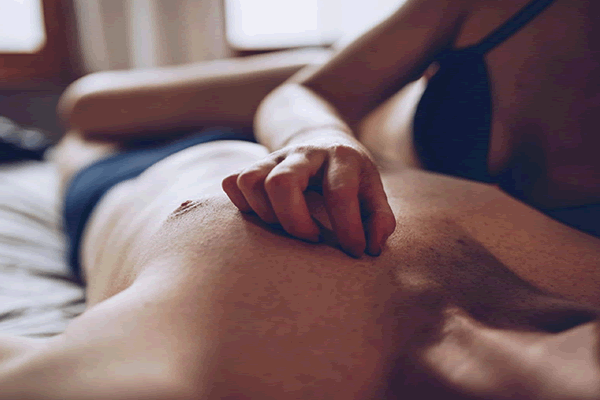 Homem recebendo massagem trântrica de uma mulher.