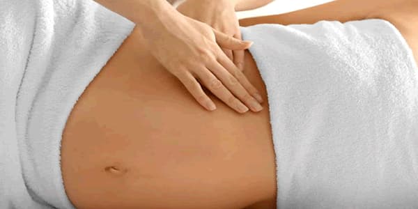 Gestante recebendo massagem pré-natal na barriga. 